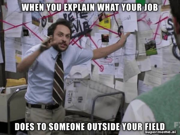 Man gestures at a wall of papers and red strings. Caption: When you explain what your job does to someone outside your field.